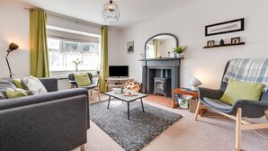 A modern living room with a fireplace, a television, and comfortable seating.