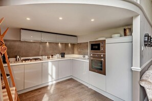 A modern kitchen with white cabinetry, a built-in oven, and a microwave. - 2 Bed in Bath (oc-bhr6) (Bath)