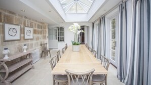 A spacious dining area with a long wooden table, stone walls, and a skylight. - 7 Bed in Combe Hay (oc-bhr21) (Combe Hay)