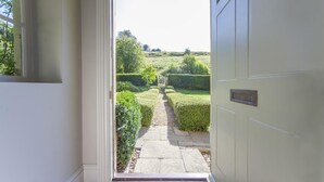A doorway leading to a well-maintained garden with a stone pathway. - 7 Bed in Combe Hay (oc-bhr21) (Combe Hay)