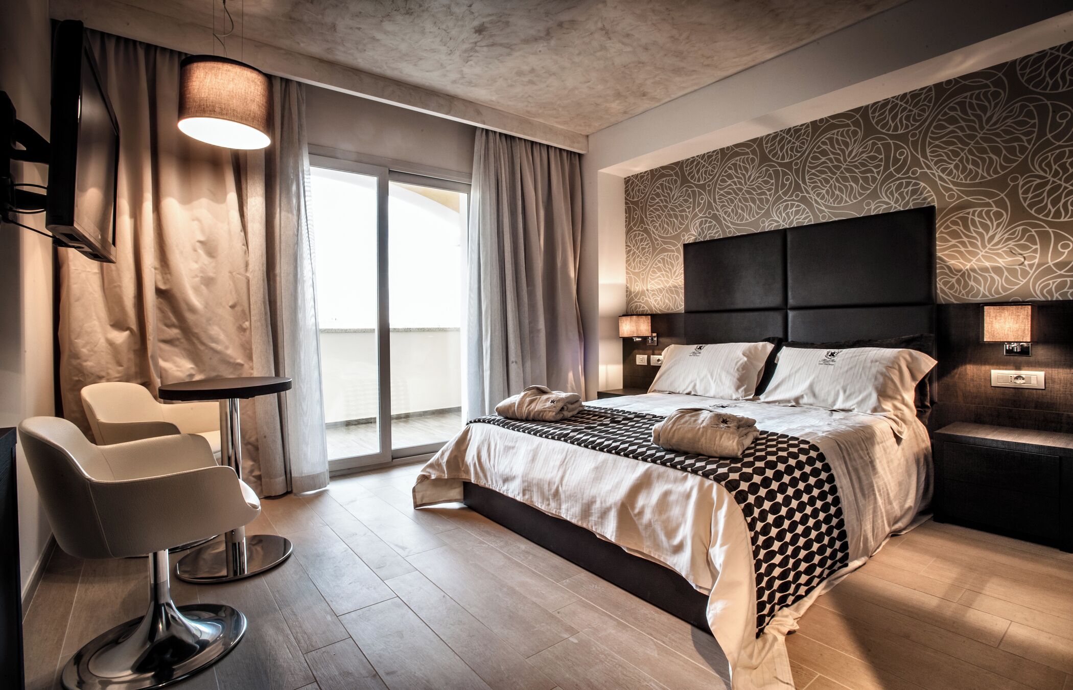 Une chambre d’hôtel moderne dotée d’un grand lit, d’un coin salon et offrant une vue sur l’extérieur.