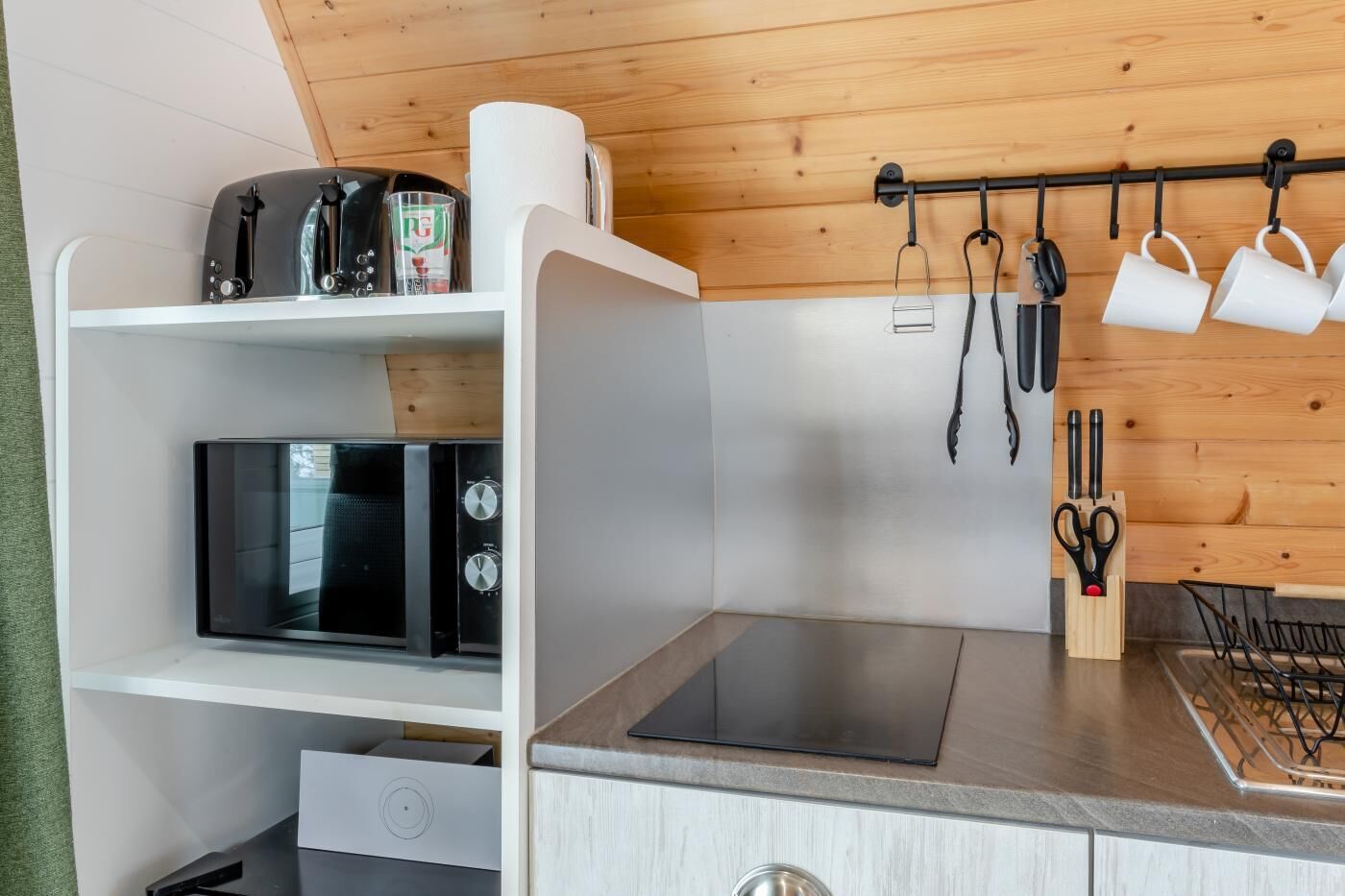 Een microgolfoven, een kinderstoel, kookgerei, borden en bestek