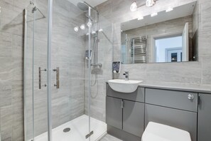 A modern bathroom with a glass-enclosed shower, a white sink, and a large mirror. - 1 Bed in Aberystwyth (oc-bow285) (Aberystwyth)