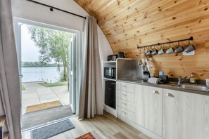 Cuina amb vista a un llac, sostre de fusta i una porta corredissa que dóna a l'exterior.