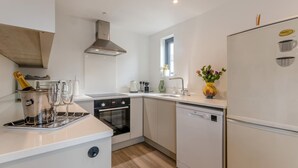 A modern kitchen with a built-in oven, a dishwasher, and a refrigerator. - 2 Bed in Holt (oc-l31797) (Holt)