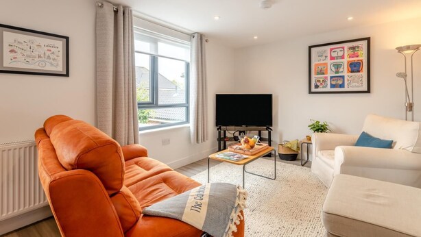 A modern living room with a sofa, a coffee table, a TV, and artwork on the walls. - 2 Bed in Holt (oc-l31797) (Holt)
