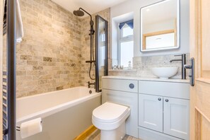 A bathroom with a bathtub, toilet, and sink.