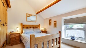 A bedroom with a wooden bed, bedside tables, a mirror, and a window with a view of a brick wall. - 2 Bed in Buxton (oc-dcwyn) (Tideswell)