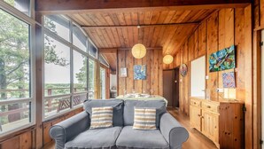 A wooden interior with a sofa, wooden cabinets, and artwork on the walls. - 3 Bed in Broad Haven (oc-wav604) (Haverfordwest)