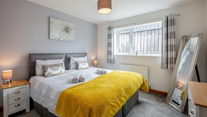 A neatly arranged bedroom with a bed, bedside tables, a mirror, and a window with curtains. - 2 Bed in Pickering (oc-d32743) (Pickering)