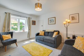 A living room with a sofa, armchair, and a coffee table. - 3 Bed in Brancaster (oc-2153) (Brancaster)