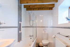 Ein Badezimmer mit Badewanne, Toilette und Dusche.