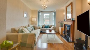 A living room with a sofa set, a coffee table, a fireplace, and a television. - 3 Bed in Heacham (oc-2203) (Heacham)