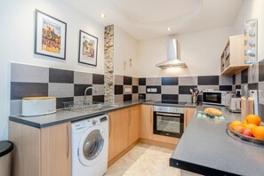 A modern kitchen with a built-in washing machine, a microwave, and a toaster.