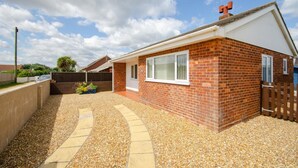 A residential property with a brick exterior, a covered patio, and a gravel driveway. - 2 Bed in Walcott (oc-2209) (Walcott)