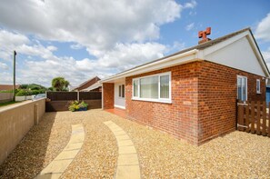 A residential property with a brick exterior, a covered patio, and a gravel driveway. - 2 Bed in Walcott (oc-2209) (Walcott)