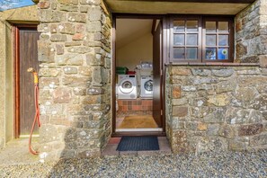Ein Steinhaus mit einer Waschküche, die zwei Waschmaschinen enthält.