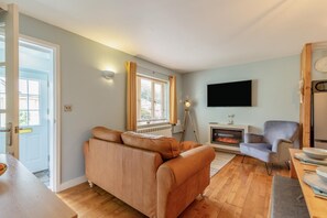 A living room with a sofa, a television, a fireplace, and a dining area. - 2 Bed in Davidstow (oc-p32812) (Davidstow)