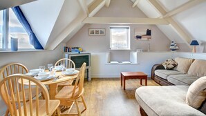 A cozy loft apartment with a dining area, a sofa, and a television. - 1 Bed in Saundersfoot (oc-pw282b) (Saundersfoot)