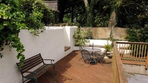 A wooden deck with a bench and a table with chairs. - 1 Bed in Saundersfoot (oc-pw282b) (Saundersfoot)