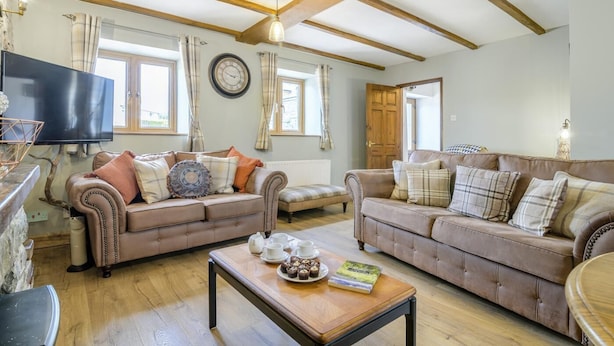 A spacious living room with two sofas, a coffee table, and a television. - 2 Bed in Cray (oc-bow287) (Crai)