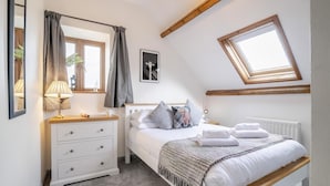A bedroom with a bed, a bedside table with a lamp, a dresser, a window with curtains, a skylight, and a framed picture on the wall. - 2 Bed in Cray (oc-bow287) (Crai)