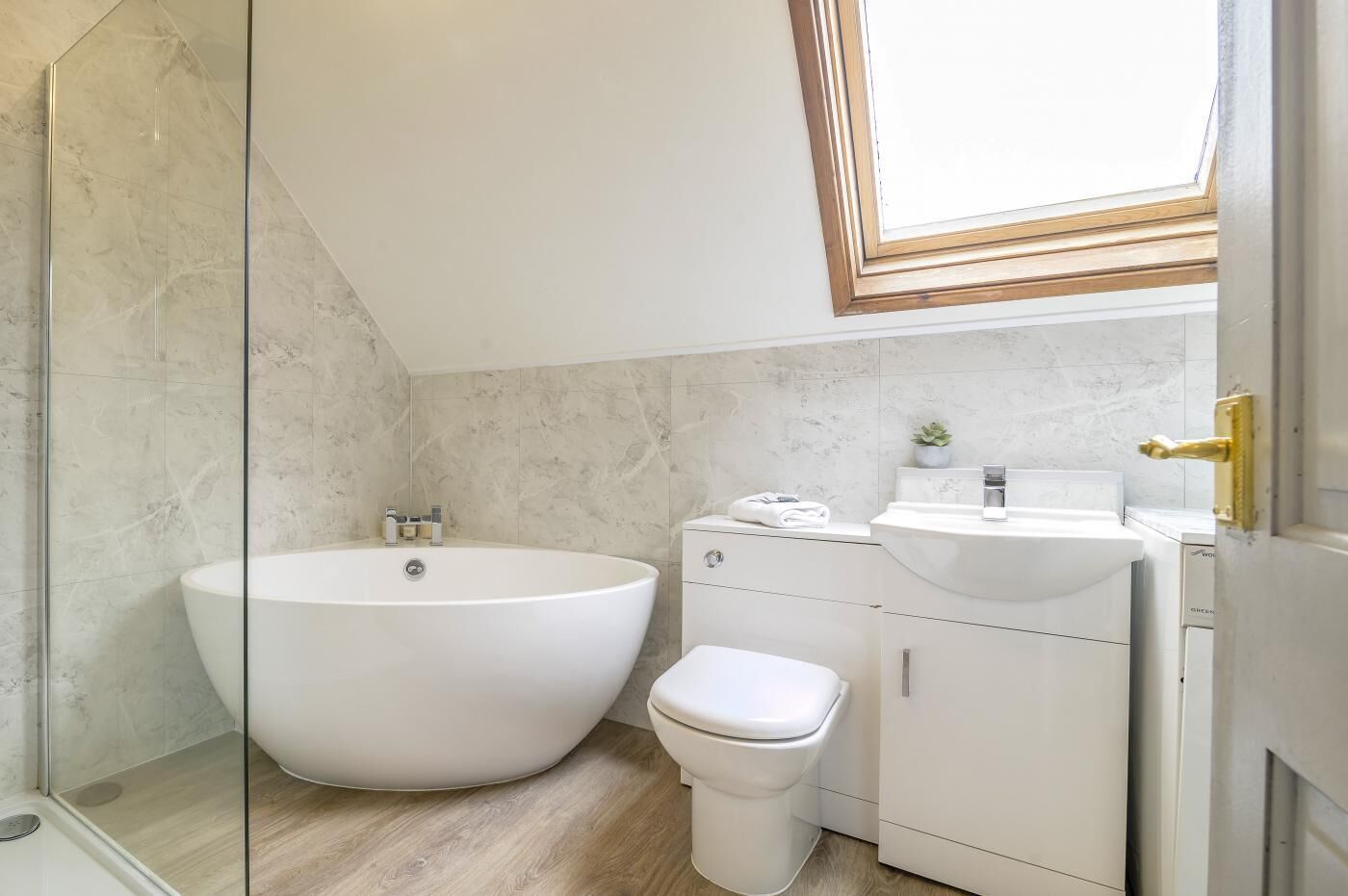 A modern bathroom with a freestanding bathtub, a toilet, and a sink.