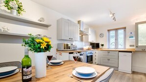 Une cuisine moderne avec des meubles blancs, un four à micro-ondes et un lave-vaisselle.