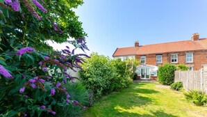 A residential house with a garden, a brick exterior, and a conservatory. - 3 Bed in Winterton-on-Sea (oc-2205) (Winterton-on-Sea)