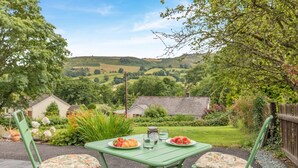 A green outdoor table with two chairs, a plate of strawberries, a glass of water, and a glass of juice. - 2 Bed in Penybontfawr (oc-b32943) (Penybontfawr)