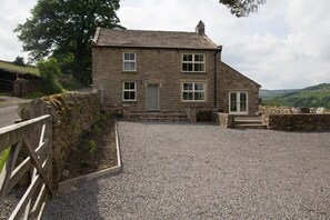 A stone house with a gravel driveway and a wooden fence. - 3 Bed in Low Row (oc-ds1030) (Low Row)
