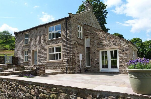 A stone building with a large window and a door. - 3 Bed in Low Row (oc-ds1030) (Low Row)