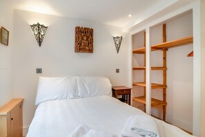 Ein Schlafzimmer mit einem Bett, einem Holzschrank und Wanddekoration.
