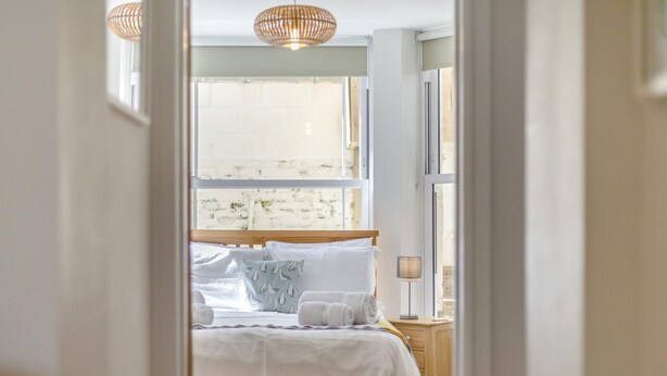 A bedroom with a bed, pillows, a bedside table, and a lamp. - 2 Bed in Cromer (oc-2202) (Cromer)