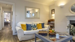 A living room with a sofa, a chessboard, a bowl of fruit, and a fireplace. - 2 Bed in Bath (oc-bhr14) (Bath)
