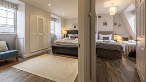 A bedroom with a large bed, a smaller bed, a sofa, and a window with shutters. - 2 Bed in Bath (oc-bhr14) (Bath)