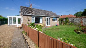 A two-story house with a tiled roof, a conservatory, and a fenced garden. - 2 Bed in Docking (oc-2212) (Docking)