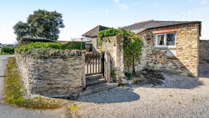 A stone house with a gravel driveway, a wooden gate, and a small porch. - 1 Bed in Padstow (oc-p00554) (Saint Merryn)