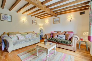 A cozy living room with wooden beams, two sofas, a coffee table, and wall-mounted lamps. - 2 Bed in Happisburgh (oc-1634) (Happisburgh)