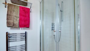 A bathroom with a glass-enclosed shower, a chrome towel rack with two towels, and a chrome towel warmer. - 1 Bed in Acle (oc-1256) (Limpenhoe)