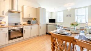 A modern kitchen with a built-in oven, microwave, and a stainless steel range hood. - 2 Bed in Seahouses (oc-nb1944) (Seahouses)