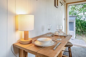 Ein Holztisch mit einer Lampe, Tellern, Gläsern und Besteck.