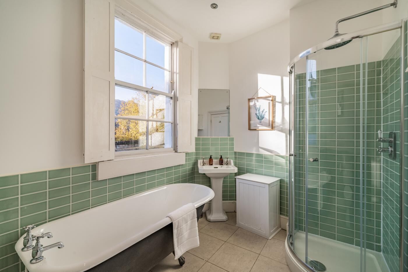 A bathroom with a bathtub, a sink, a toilet, and a shower area.