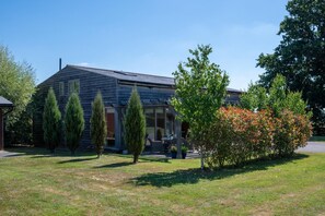 A two-story wooden house with a covered porch, surrounded by a well-maintained lawn and various trees. - 1 Bed in Beckley (oc-rh1151) (Beckley)