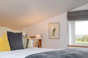 A bedroom with a bed, pillows, a bedside lamp, a framed picture, and a window with a view. - 1 Bed in Beckley (oc-rh1151) (Beckley)
