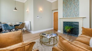 Una sala de estar con chimenea, un comedor con mesa y sillas, y un espacio de descanso con sofás.