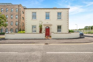 Un bâtiment à deux étages avec une porte rouge et de nombreuses fenêtres.