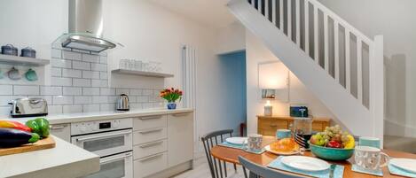 Een oven, een vaatwasser, een kinderstoel, kookgerei, borden en bestek