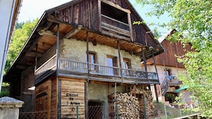 Perinteinen alppimaja, jossa on puinen julkisivu, parveke ja kyltti, jossa lukee: ”Chalet de l’Arvan”.