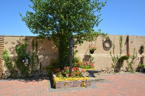 A courtyard with a brick pathway, a tree, and flower beds. - 1 Bed in Blofield Heath (oc-1468) (Blofield)